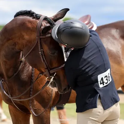 Rider in navy coat number 436 resting head against bay horse